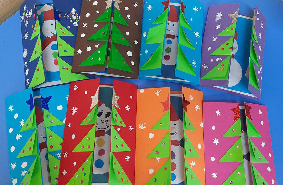 Дети рисуют рождественские открытки в школе под высоким углом, копируют пространство